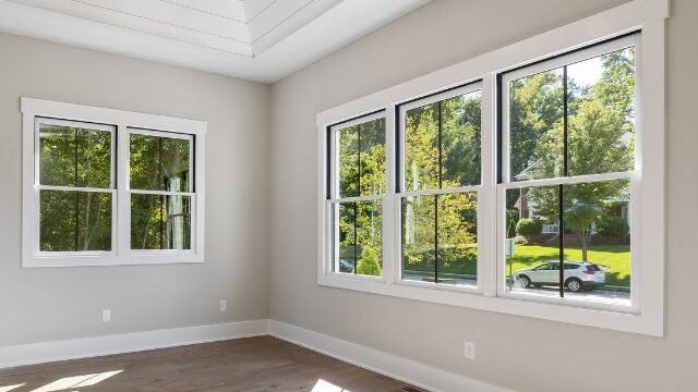 a room with windows and wood floors