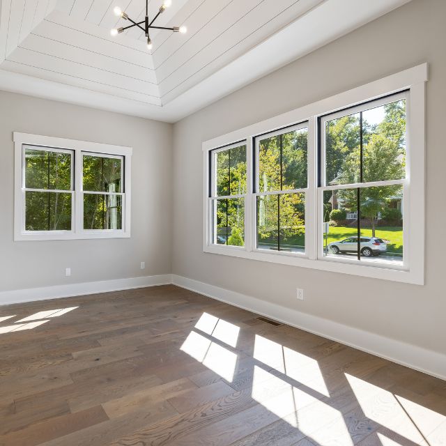 a room with windows and wood floors